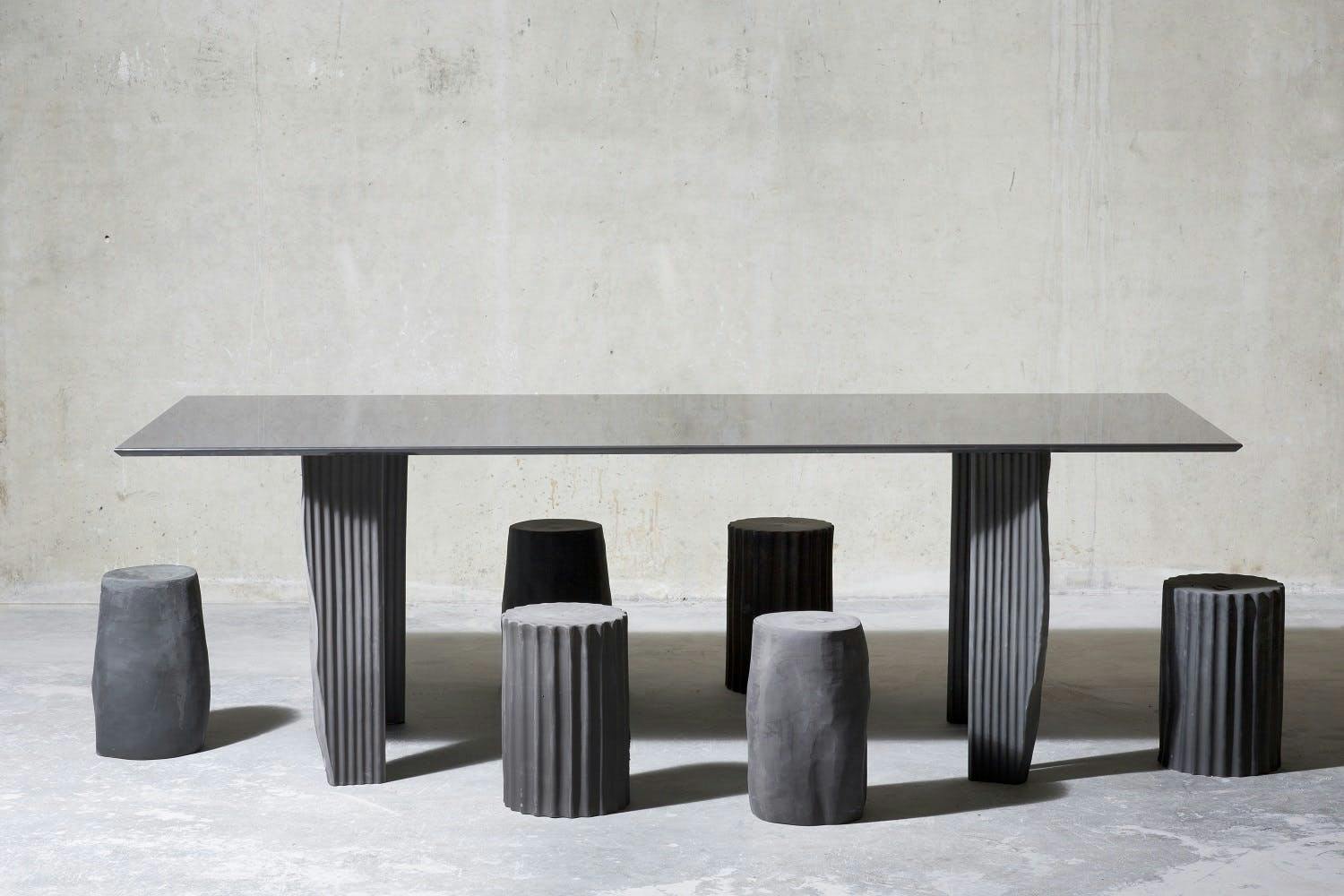 Ein grauer Tisch mit Sitzgelegenheiten aus organische Formen.