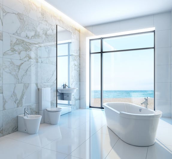 Badezimmer aus weißem Marmor mit Blick auf das Meer. 